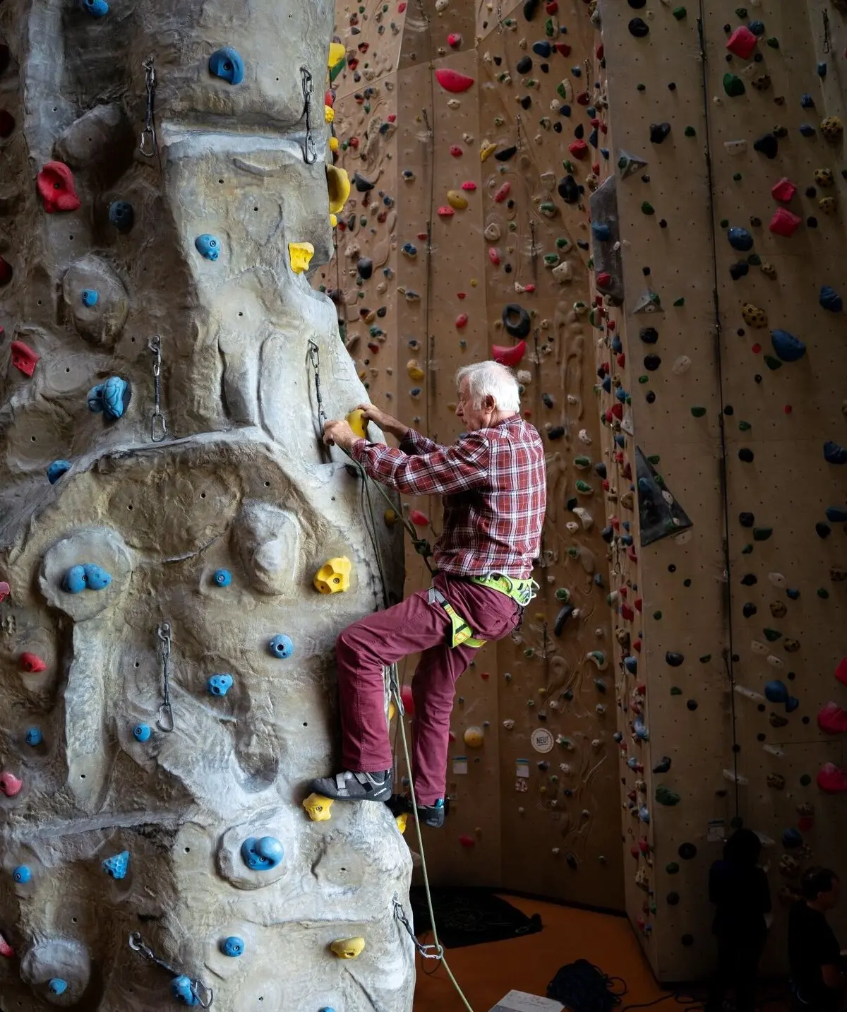 Ein Senior klettert gesichert in einer Kletterhalle | © DAV / Julian Rohn