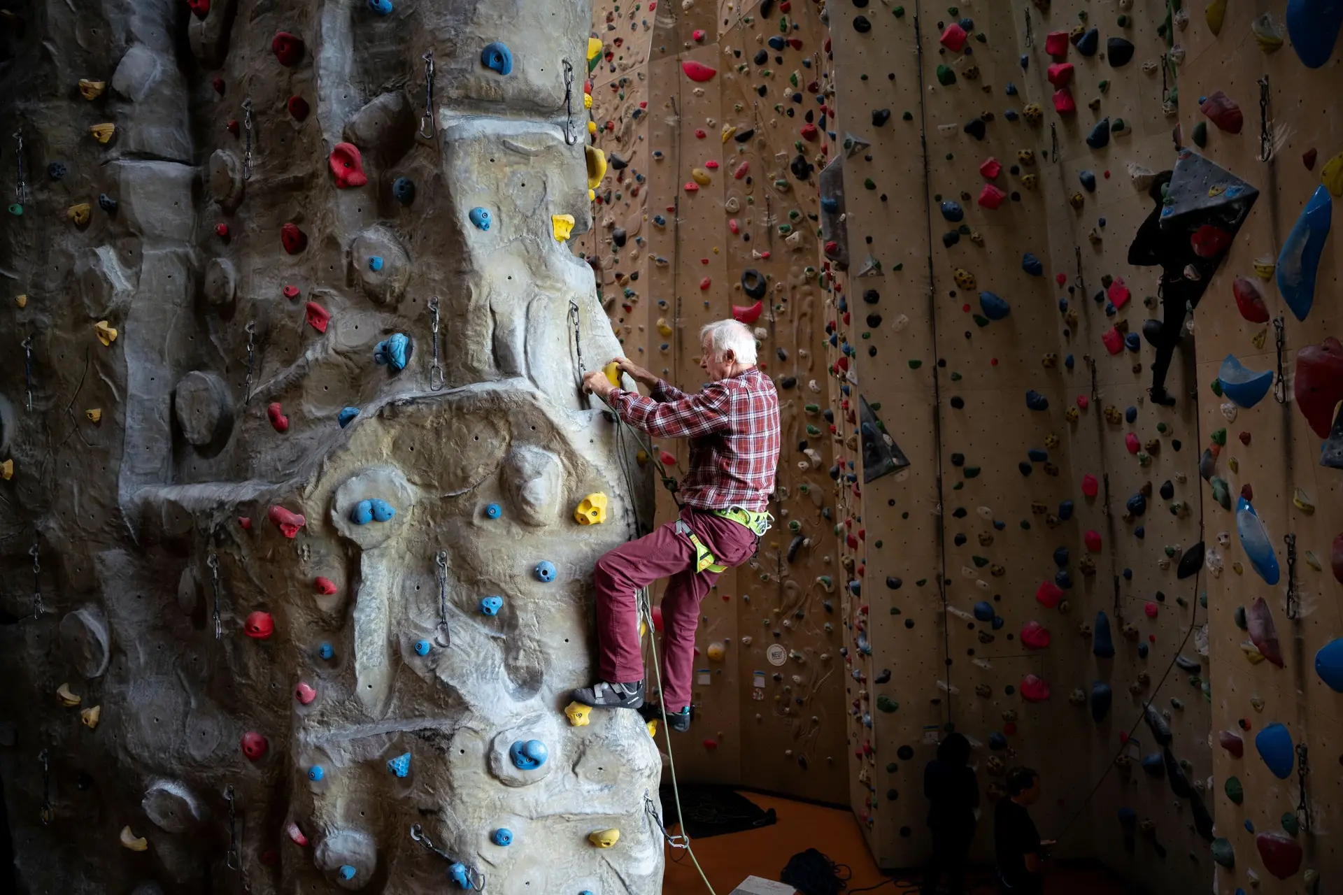Ein Senior klettert gesichert in einer Kletterhalle | © DAV / Julian Rohn