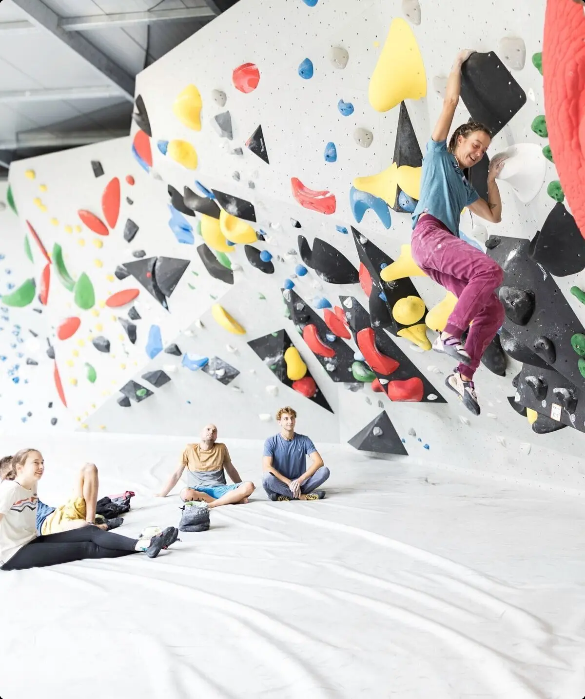 Eine Frau beim Bouldern, im Hintergrund warten weitere Personen, bis sie an der Reihe sind | © DAV / Jens Klatt